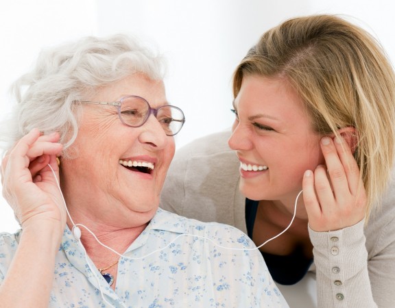 Excited grandmother listening music together with her granddaugh